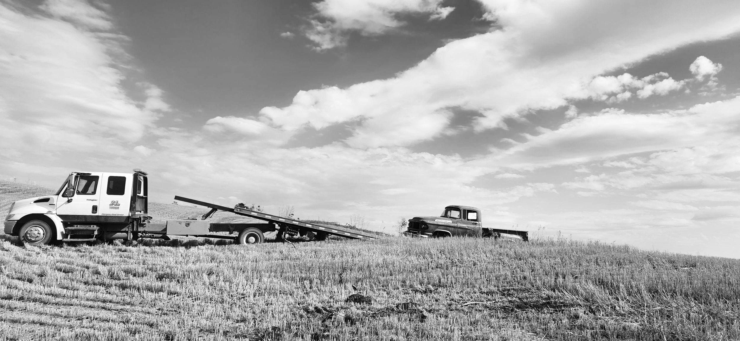 Bro's Tows flatbed loading a truck on a Saskatchewan prairie